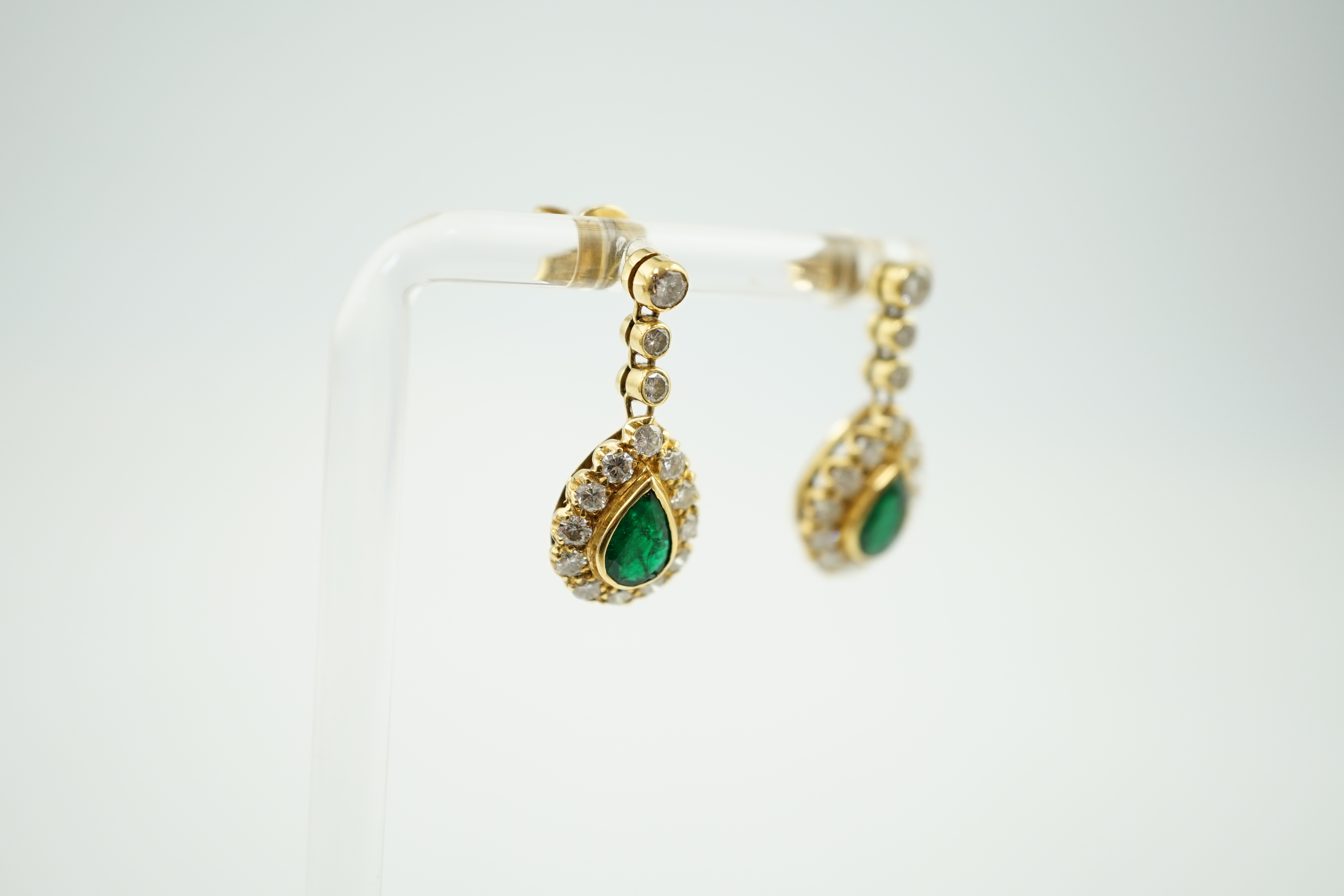 A modern pair of 18ct gold, emerald and diamond cluster set pear shaped drop earrings